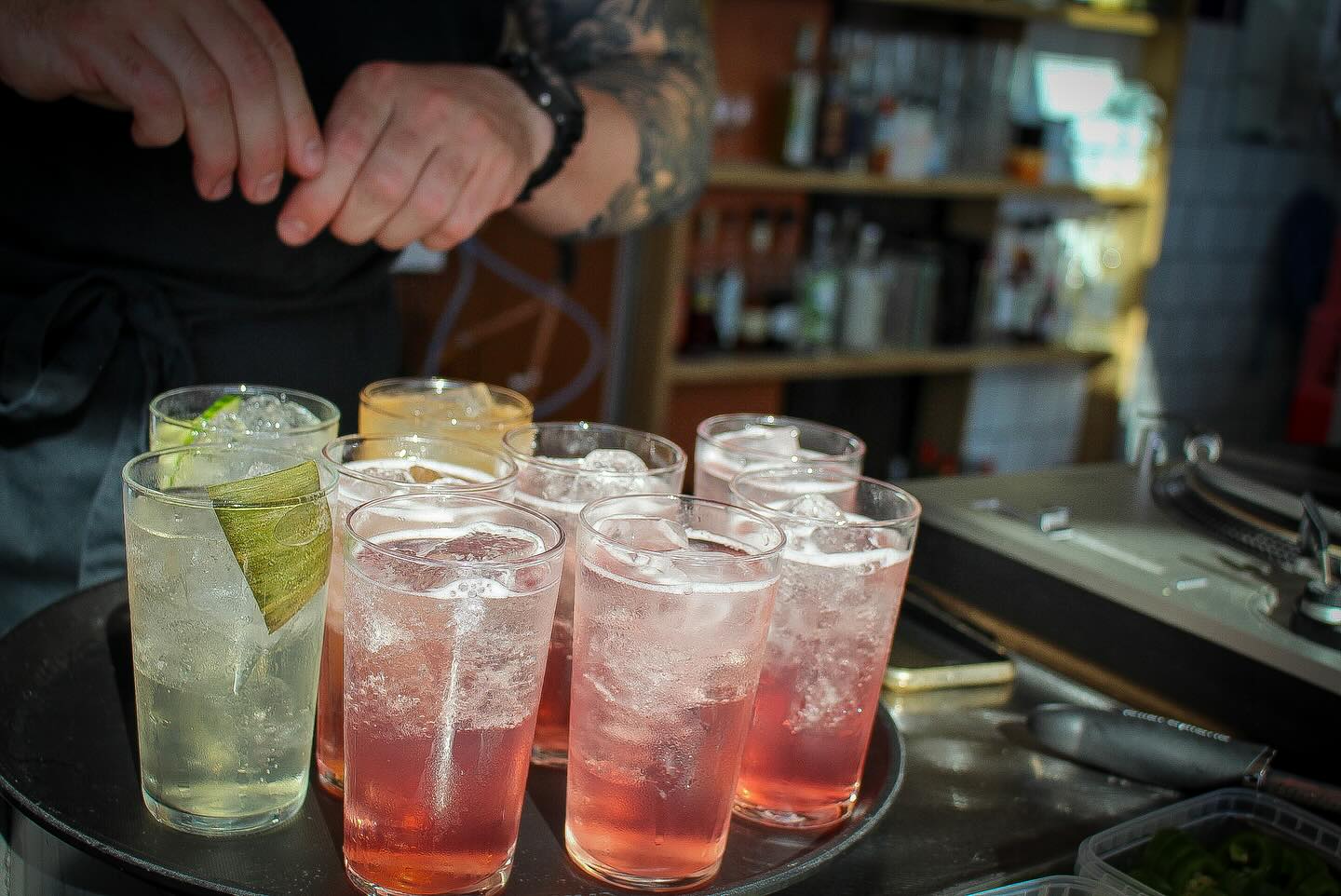 A tray of fresh highballs and pink spritzes at the bar